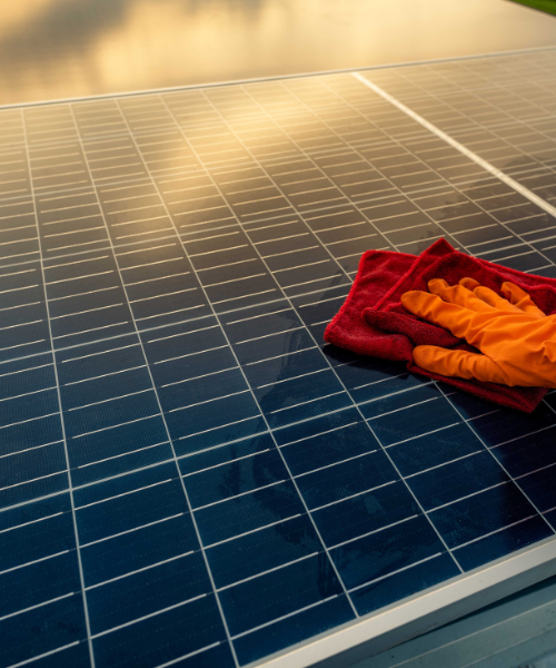 A red and orange towel laying on top of a solar panel